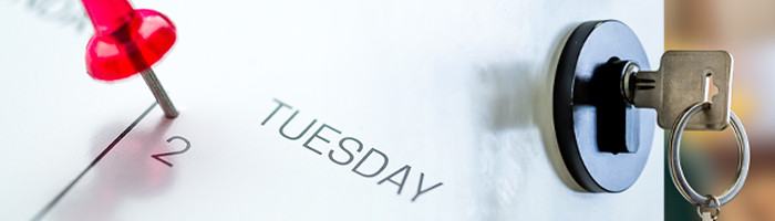Photo of red push pin on Tuesday of calendar page next to image of door keyhole with key and keyring