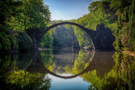 Beautiful arched walking bridge over a river in Bavaria, Germany