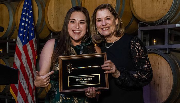 2023 President Marla Perego accepting the ceremonial gavel from outgoing 2022 President Jessica Eva at the 2023 Installation ceremony on January 19, 2023 at Domenico Winery