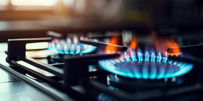 Photo of gas stove burner with blue flame.
