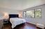 Bedroom with tree top views and hardwood flooring (Image 11)